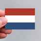 A hand holding a Dutch flag sticker