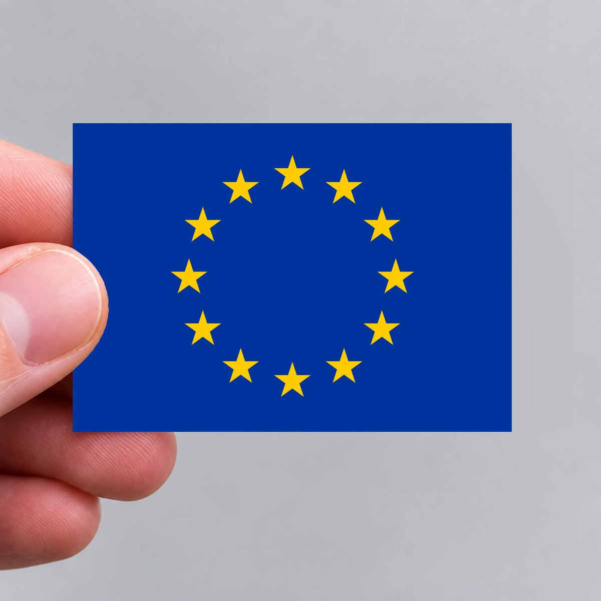 A hand holding a European Union flag sticker by Gobrecht & Ulrich