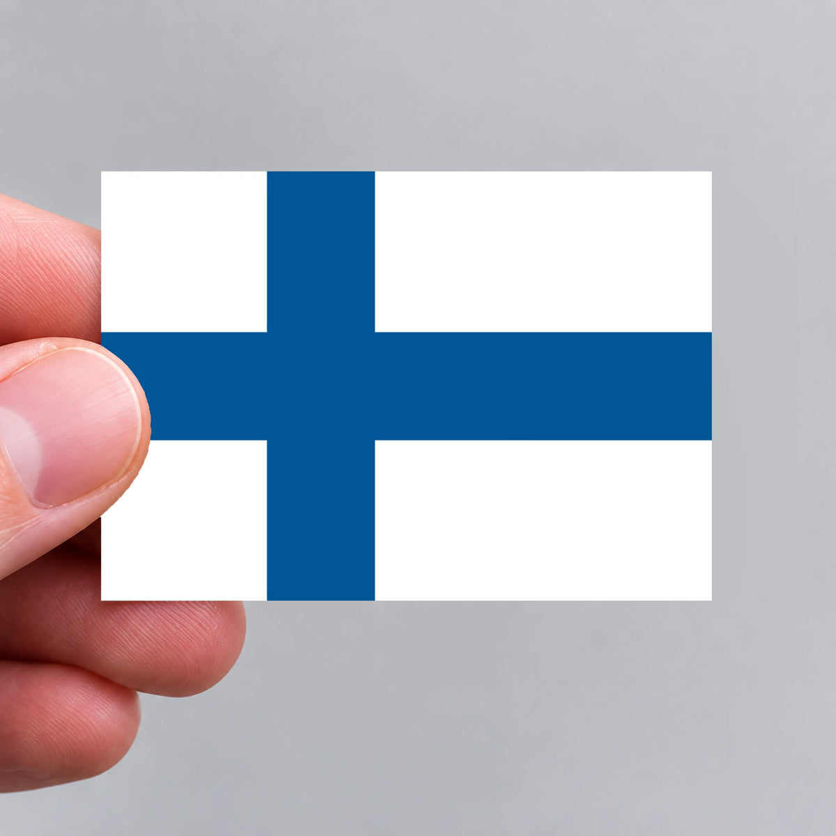 A hand holding a Finnish flag sticker by Gobrecht & Ulrich