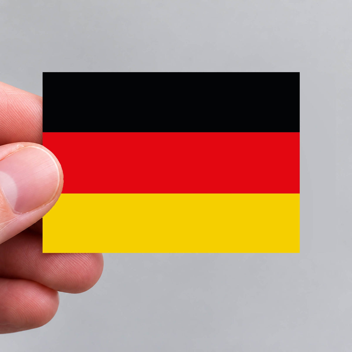 A hand holding a German flag sticker