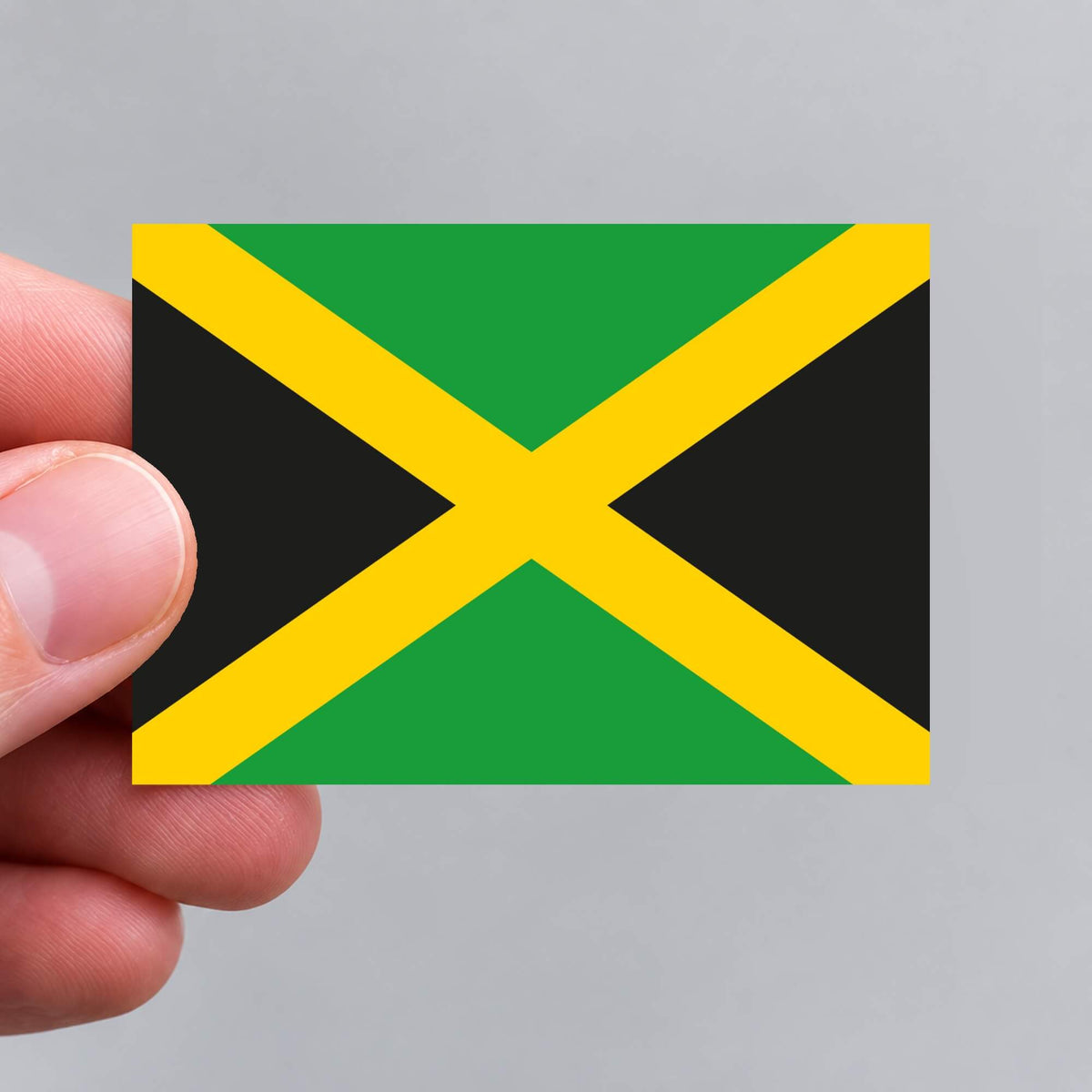 A hand holding a Jamaican flag sticker by Gobrecht & Ulrich