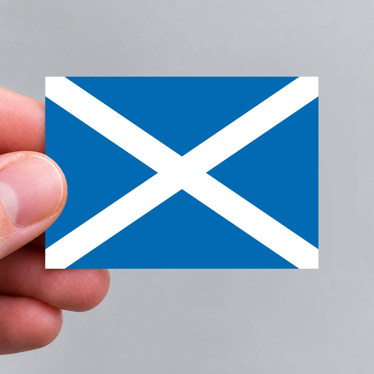 A hand holding a Scottish flag sticker by Gobrecht & Ulrich