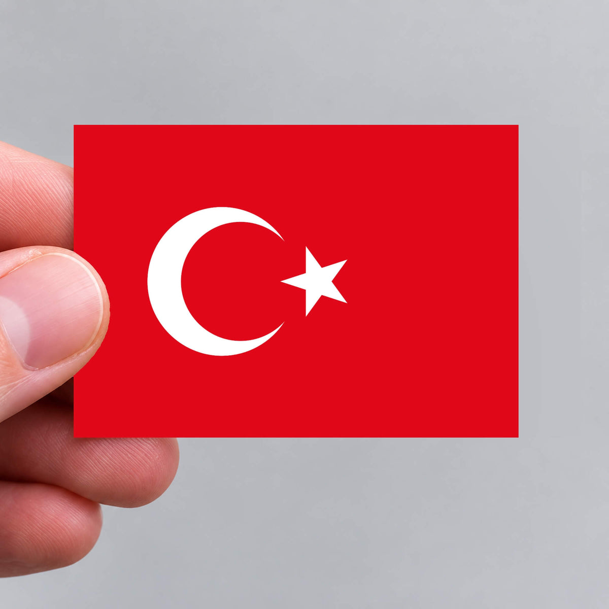 A hand holding a Turkish flag sticker by Gobrecht & Ulrich