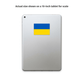 A silver tablet shown from the back with a blue and yellow Ukrainian flag sticker centered on the upper half. Text above reads, 'Actual size shown on a 10-inch tablet for scale.