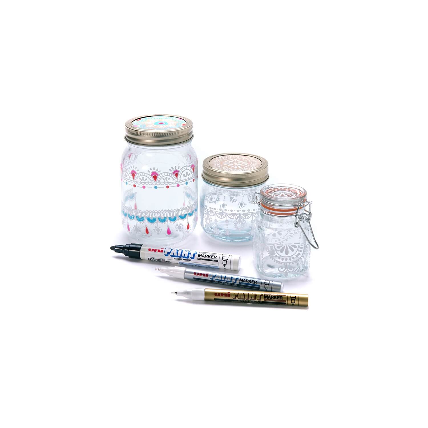 Set of glass jars with metal lids and markers on a white background