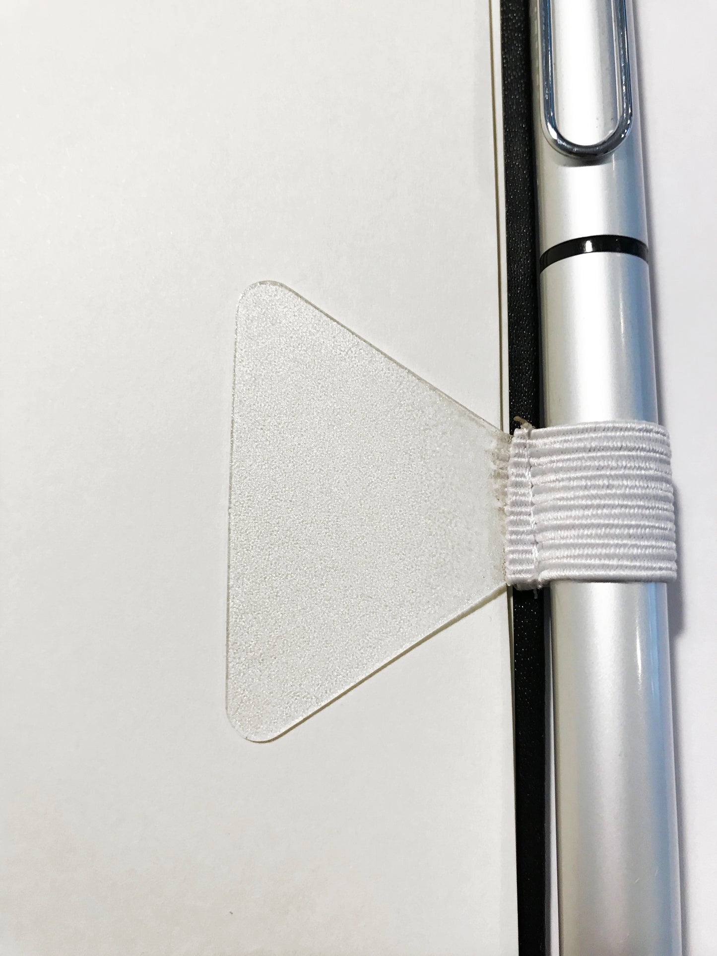 White Self-adhesive Pen Loop - Elastic White Pen Holder by Gobrecht & Ulrich attached to back of notebook